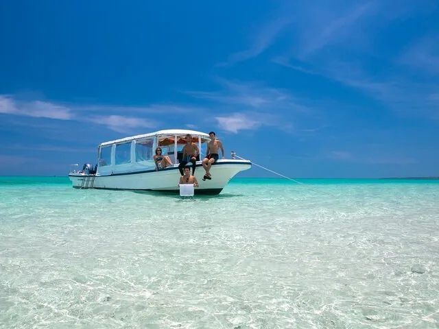 Turistas en un barco en aguas claras y poco profundas